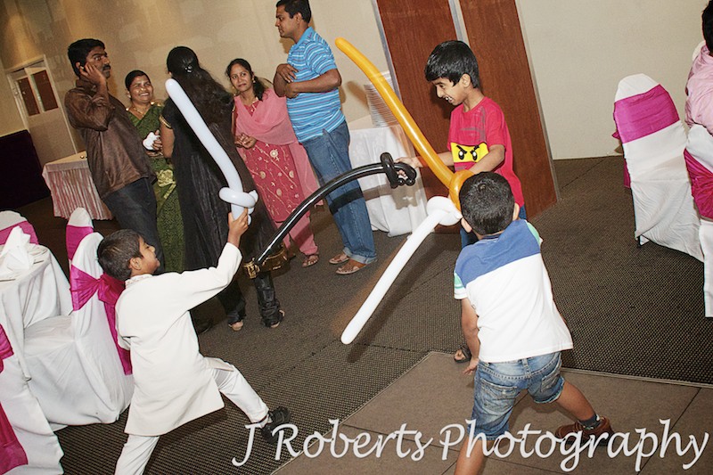 Little boys playing with balloon swords at birthday party - party photography sydney